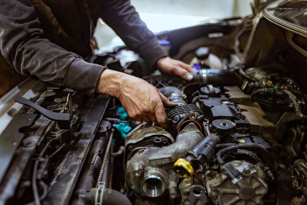 Professional mechanic repairing an engine block and diagnosing complex automotive faults in the garage